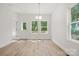 Light-filled dining space with wood-look floors and view to a wooded area at 54 Reed Ne St, Concord, NC 28025
