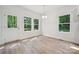 Bright dining area with wood-look floors and a view of wooded area through several windows at 54 Reed Ne St, Concord, NC 28025