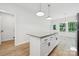 Bright kitchen with white cabinets, an island with stone countertop, and stainless steel appliances at 54 Reed Ne St, Concord, NC 28025