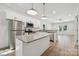 Open kitchen with stainless steel appliances, white cabinets, and an island with granite countertop at 54 Reed Ne St, Concord, NC 28025