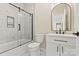 Bathroom with a tub-shower combo featuring glass doors, white tile and a sleek modern vanity at 6249 Hayden Dr, Hickory, NC 28601