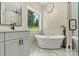 Modern bathroom features a soaking tub, sleek fixtures, and a window overlooking the green outdoors at 6249 Hayden Dr, Hickory, NC 28601