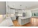 Modern kitchen with white cabinets, quartz countertops, and stainless steel appliances, flowing into the living area at 6249 Hayden Dr, Hickory, NC 28601