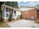 Backyard view of the home with patio, screened porch, and a brick accent wall at 6300 Morehead Rd, Harrisburg, NC 28075