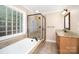 Bright bathroom featuring a soaking tub, glass-enclosed shower, and granite vanity at 6300 Morehead Rd, Harrisburg, NC 28075