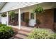 Inviting front porch with brick steps, rocking chairs, and potted plants at 6300 Morehead Rd, Harrisburg, NC 28075