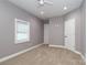 Bedroom with neutral carpet, gray walls, white trim, ceiling fan, and a window for natural light at 6310 Forney Hill Rd, Denver, NC 28037