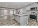 Spacious kitchen with stainless appliances, gray cabinets, a granite island and wood look flooring at 6310 Forney Hill Rd, Denver, NC 28037