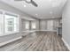 Bright living room features wood-look floors, recessed lighting, and large windows at 6310 Forney Hill Rd, Denver, NC 28037