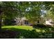 Secluded backyard featuring mature trees, manicured lawn, and a charming deck for relaxing outdoors at 6507 Fairway Point Dr, Charlotte, NC 28269