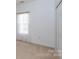 Well-lit bedroom with neutral walls and carpet, complemented by a bright window with colorful curtains at 6507 Fairway Point Dr, Charlotte, NC 28269