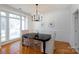 Bright dining room with large windows, hardwood floors, and an elegant chandelier above the table setting at 6507 Fairway Point Dr, Charlotte, NC 28269