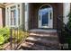 Inviting brick entryway with iron railings, leading to an arched doorway and prominent street number display at 6507 Fairway Point Dr, Charlotte, NC 28269