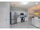 Modern kitchen featuring stainless steel appliances, white cabinets, and tiled floors and direct view to the dining area at 6507 Fairway Point Dr, Charlotte, NC 28269