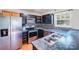 Galley kitchen featuring stainless steel appliances, black cabinetry and tile backsplash at 6922 Brandon Chase Ln, Concord, NC 28025