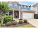 Close up of a two-story home featuring brick and gray siding, a two-car garage, and landscaped front yard at 6961 Liverpool Ct, Fort Mill, SC 29707