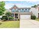 Two-story home featuring brick and gray siding, a two-car garage, well-maintained lawn and landscaped front yard at 6961 Liverpool Ct, Fort Mill, SC 29707
