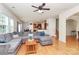 Open-concept living room with hardwood floors and large sectional sofa flowing into kitchen at 6961 Liverpool Ct, Fort Mill, SC 29707