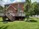 Expansive backyard featuring a deck, lush lawn, and a classic brick home exterior at 7318 Brighton Brook Dr, Charlotte, NC 28212