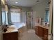 Bathroom featuring dual sinks, walk-in shower, tub, and tiled floor at 7318 Brighton Brook Dr, Charlotte, NC 28212