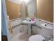 This bathroom features a pedestal sink, toilet, tile walls, and a mirror at 7318 Brighton Brook Dr, Charlotte, NC 28212