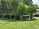 Community entrance with 'Brighton Woods' sign, mature trees, and manicured lawn at 7318 Brighton Brook Dr, Charlotte, NC 28212