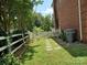 Side yard featuring a white picket fence, stepping stones, and brick exterior at 7318 Brighton Brook Dr, Charlotte, NC 28212