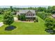 Expansive aerial view of a stately brick home with a well-maintained lawn and lush, mature landscaping throughout the property at 8137 Caliterra Dr, Charlotte, NC 28227