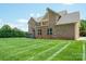 Brick home with green, expansive lawn and upper balcony providing space for outdoor enjoyment at 8137 Caliterra Dr, Charlotte, NC 28227