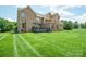 Expansive backyard with well-maintained lawn and brick home featuring a deck and upper-level balcony at 8137 Caliterra Dr, Charlotte, NC 28227