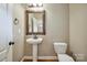 Charming bathroom with pedestal sink, stylish mirror and fixtures at 8137 Caliterra Dr, Charlotte, NC 28227