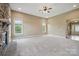 Bright living room with a cozy stone fireplace and large windows offering scenic views at 8137 Caliterra Dr, Charlotte, NC 28227