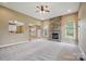 Spacious living room featuring a stone fireplace, plush carpet, and abundant natural light at 8137 Caliterra Dr, Charlotte, NC 28227
