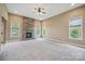 Spacious living room has plush carpet, a stone fireplace, and bright windows; offering a comfortable and inviting atmosphere at 8137 Caliterra Dr, Charlotte, NC 28227