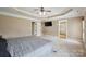 Main bedroom featuring a tray ceiling, ceiling fan, carpet and access to other rooms at 8137 Caliterra Dr, Charlotte, NC 28227