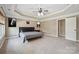 Main bedroom featuring a tray ceiling, ceiling fan, carpet, and a door to the bathroom at 8137 Caliterra Dr, Charlotte, NC 28227