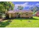 The back of a brick house is displayed with manicured lawn, an AC unit, and back door at 823 Yuma St, Charlotte, NC 28213