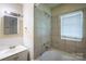 Modest bathroom featuring a shower-tub combo, single sink vanity, and window, providing a functional space at 823 Yuma St, Charlotte, NC 28213