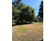 Spacious backyard featuring a large shade tree and storage shed, perfect for outdoor activities at 830 Mcarthur Ave, Charlotte, NC 28206