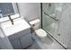 Modern bathroom featuring marbled shower and a gray vanity with white countertop and gold hardware at 830 Mcarthur Ave, Charlotte, NC 28206