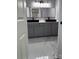 Modern bathroom featuring double sinks with black basins, gray cabinetry and marble-patterned tile floors at 830 Mcarthur Ave, Charlotte, NC 28206