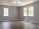 Living room with three windows, new flooring, and neutral paint at 830 Mcarthur Ave, Charlotte, NC 28206