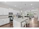 Open kitchen with white cabinets, stainless appliances, and granite island flowing into the living area at 9620 Ainslie Downs St, Charlotte, NC 28273