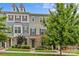 Attractive multi-colored townhome featuring a stone facade, lush lawn, and mature trees at 9620 Ainslie Downs St, Charlotte, NC 28273
