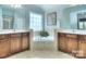 Bright bathroom featuring a soaking tub, double vanity, and large windows at 9792 Ravenscroft Nw Ln, Concord, NC 28027