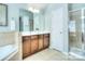 Well-lit bathroom showcasing a glass enclosed shower and double vanity sink at 9792 Ravenscroft Nw Ln, Concord, NC 28027