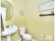 A quaint powder room features a pedestal sink, and light neutral colored walls at 9792 Ravenscroft Nw Ln, Concord, NC 28027