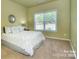 Cozy bedroom featuring a queen-sized bed, carpeted floors, and a large window at 9792 Ravenscroft Nw Ln, Concord, NC 28027