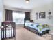Inviting bedroom with neutral tones, plush carpet, and a decorative Route 66 sign at 9792 Ravenscroft Nw Ln, Concord, NC 28027