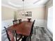 Elegant dining room with wainscoting, modern chandelier, and wood-look flooring at 9792 Ravenscroft Nw Ln, Concord, NC 28027